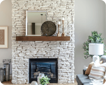 Stylish living room with a wood insert ﬁreplace built into a stone wall, complementing modern decor in Stateline, CA.